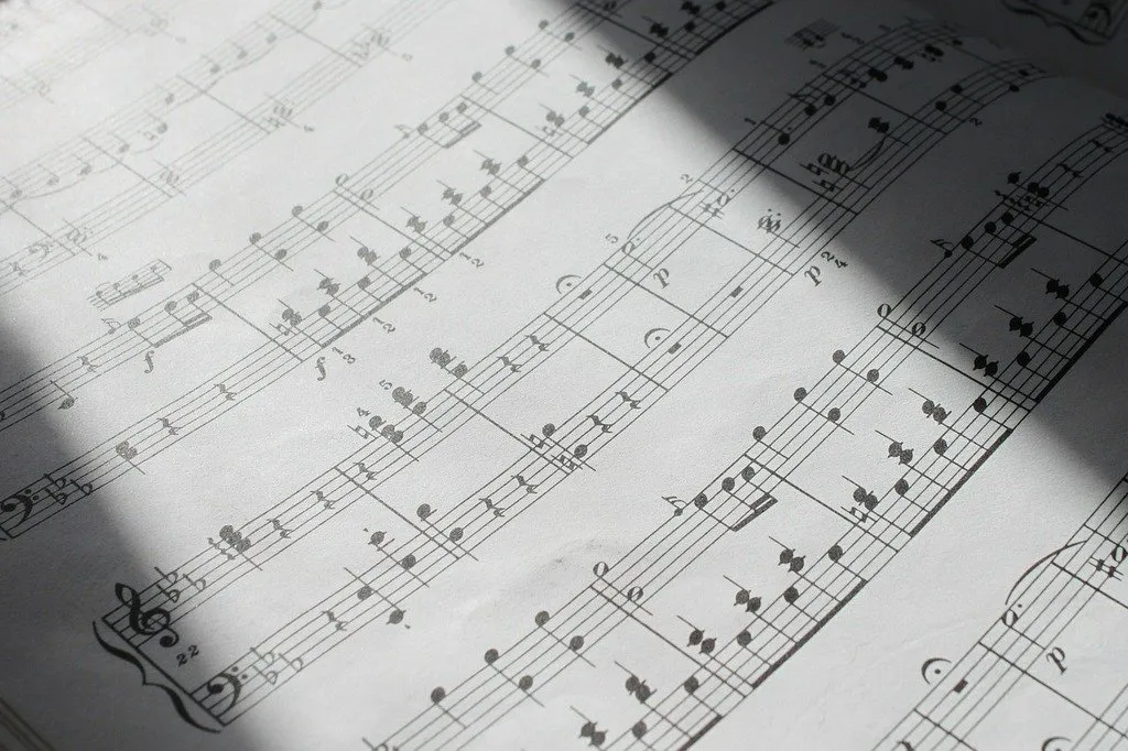 Classical sheet music notation background for Sam Desmet's guitar arrangements