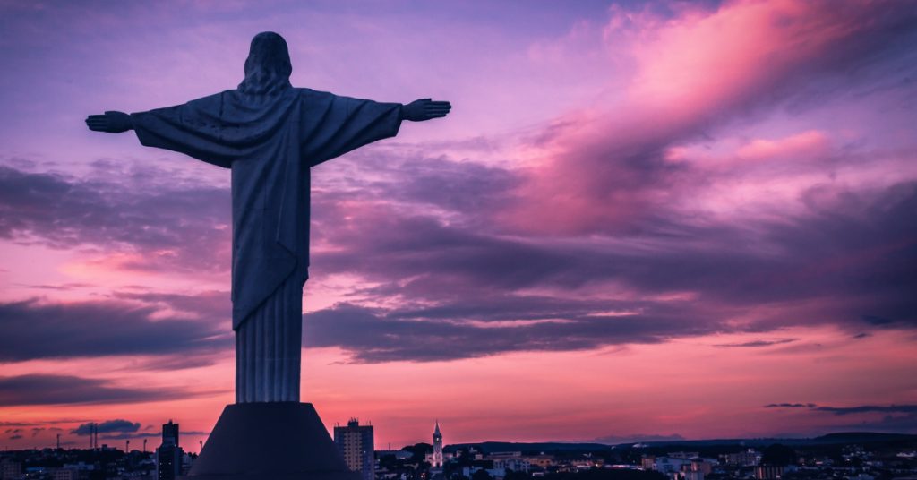 Majestic Christ the Redeemer statue overlooking Rio de Janeiro at sunset. Iconic Brazilian landmark with stunning sunset backdrop.