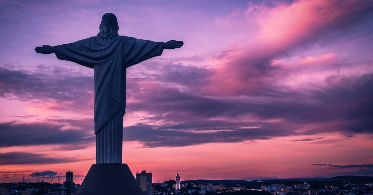 Majestic Christ the Redeemer statue overlooking Rio de Janeiro at sunset. Iconic Brazilian landmark with stunning sunset backdrop.